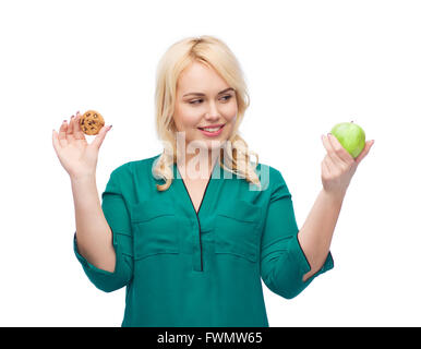 lächelnde Frau die Wahl zwischen Apple und cookie Stockfoto