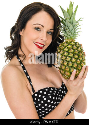 Gesunden attraktive junge Frau hält eine frische reife Ananas auf dem weißen Hintergrund isoliert Stockfoto