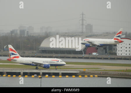 Die zwei British Airways A318 "Baby-Bus" jets am London City Airport - G-EUNA zu fahren, wie G-EUNB kommt Stockfoto