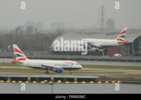 Die zwei British Airways A318 "Baby-Bus" jets am London City Airport - G-EUNA zu fahren, wie G-EUNB kommt Stockfoto