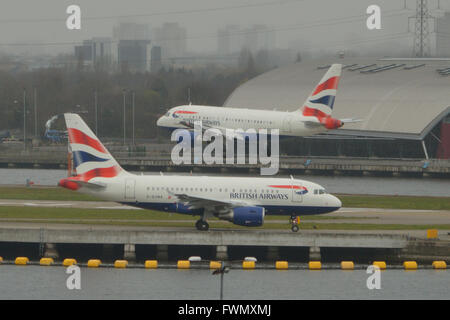 Die zwei British Airways A318 "Baby-Bus" jets am London City Airport - G-EUNA zu fahren, wie G-EUNB kommt Stockfoto