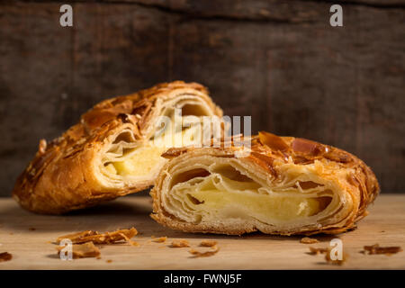 Abschnitt von einem Strudel mit Mandeln und Vanille-Eis über rustikale Holz Hintergrund Stockfoto