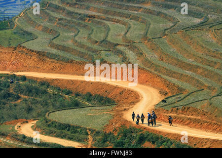 Reisenden und Hmong Dorfbewohner gehen auf Kurve Feldweg in Sapa mit und Paddel Reisfeld Stockfoto