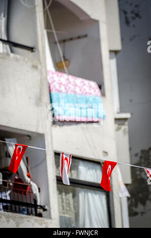 Türkische Bunting fliegen zwischen Balkone auf Flats in Kyrenia, Nordzypern. Stockfoto