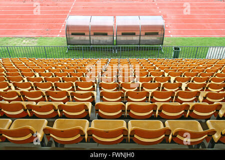 Trainer und Reserve Bänke mit gelben Sitze im Fußballstadion wieder Perspektive Stockfoto