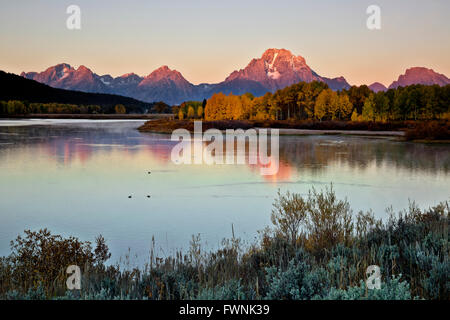 WYOMING - Sonnenaufgang vom Ufer des Snake River von Oxbow Bend mit Mount Moran in der Ferne aufragende angesehen. Stockfoto