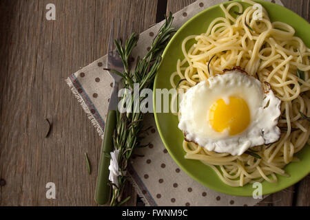 Spaghetti mit Spiegelei und Rosmarin auf grüne Platte selektiven Fokus Draufsicht Stockfoto