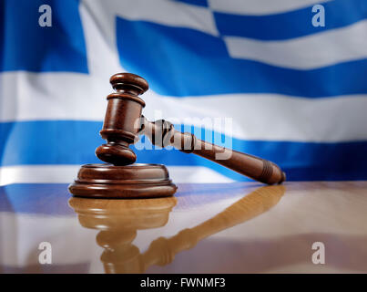 Mahagoni Holz Hammer auf glänzende Holztisch, Flagge von Griechenland im Hintergrund. Stockfoto