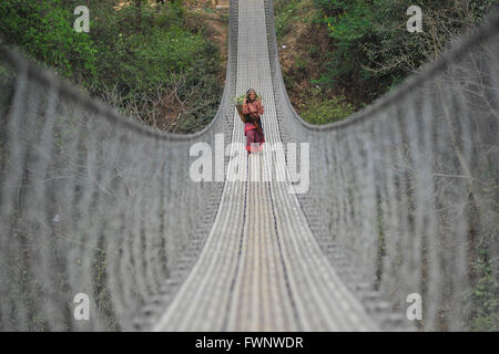 Kathmandu, Nepal. 6. April 2016. Eine alte Frau Weg zurück nach Hause von der langen Brücke nach Grass für Haustiere bei Chhampi, Lalitpur, Nepal zu sammeln. © Narayan Maharjan/Pacific Press/Alamy Live-Nachrichten Stockfoto