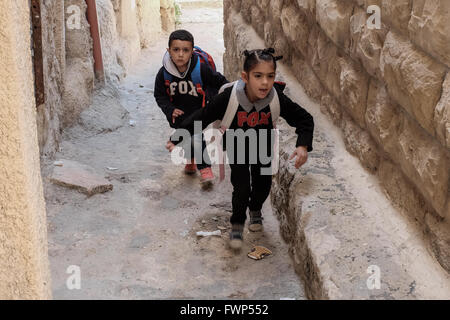 Jerusalem, Israel. 7. April 2016. Junge palästinensische Kinder durchlaufen einer der engen Straßen und Gassen von Silwan. Eine geschätzte 500 Juden in Israel leben derzeit in Kfar Shiloach unter 45.000 palästinensische Araber, die das Dorf Silwan nennen und betrachten die Juden illegale Siedler. Die meisten Land Angebote wurden von Ateret Cohanim, einer israelischen jüdischen Organisation orchestriert die Arbeiten für die Erstellung von eine jüdische Majorität in den arabischen Vierteln in Ost-Jerusalem behauptete, alle Grundstücke legitim und legal beschäftigt. Stockfoto