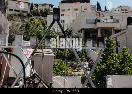 Jerusalem, Israel. 7. April 2016. Jüdische Menorah steht auf dem Dach des nenne jüdischen Einwohner Bet Frumkin, während die palästinensische Flagge auf einer Terrasse eines angrenzenden Hauses im Hintergrund fliegt. Eine geschätzte 500 Juden in Israel leben derzeit in Kfar Shiloach unter 45.000 palästinensische Araber, die das Dorf Silwan nennen und betrachten die Juden illegale Siedler. Die meisten Land Angebote wurden von Ateret Cohanim, einer israelischen jüdischen Organisation orchestriert die Arbeiten für die Erstellung von eine jüdische Majorität in den arabischen Vierteln in Ost-Jerusalem behauptete, alle Grundstücke legitim und legal beschäftigt. Stockfoto