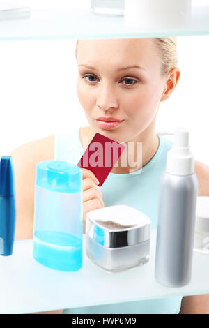 Eine Frau steht auf dem Client-Regal und wählt Kosmetik. Stockfoto
