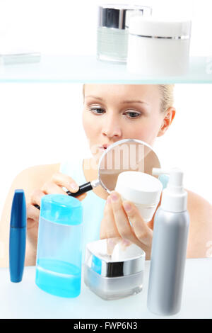 Eine Frau steht auf dem Client-Regal und wählt Kosmetik. Stockfoto