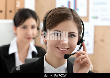 Porträt des Callcenterarbeitskraft von ihrem Team begleitet. Lächelnde Kunden-Support-Mitarbeiter bei der Arbeit. Hilfe und support-Konzept Stockfoto