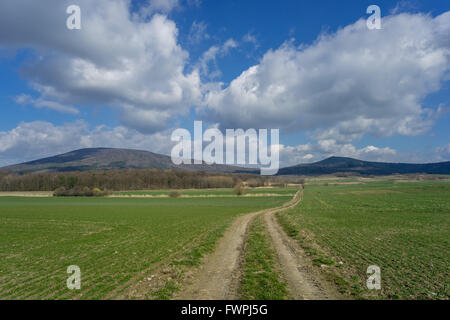 Mount Sleza und Mount Radunia mit sonnigen Frühlingshimmel, grünen Wiesen und unbefestigte Straße untere Schlesien Nieder Schlesien Stockfoto