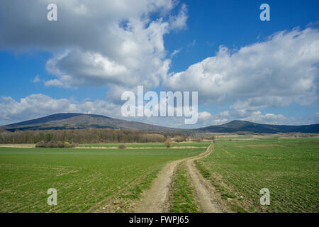 Mount Sleza und Mount Radunia mit sonnigen Frühlingshimmel, grünen Wiesen und unbefestigte Straße untere Schlesien Nieder Schlesien Stockfoto