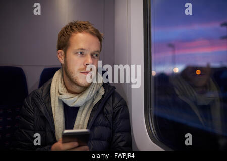 Mann sitzt im Zug Wagen senden SMS Stockfoto