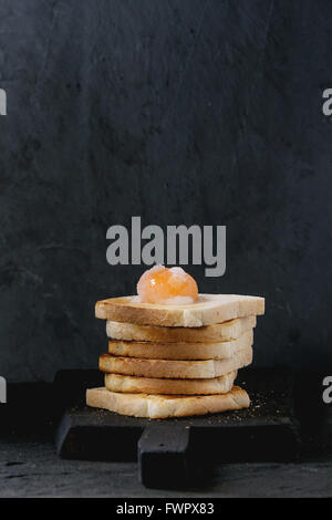 Toast mit Eigelb über schwarz Stockfoto