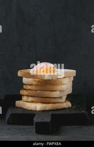 Toast mit Eigelb über schwarz Stockfoto