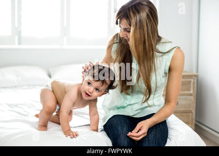 Mutter mit lächelnden Sohn auf Bett Stockfoto