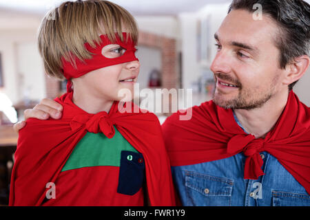 Vater und Sohn, die vorgibt, Superheld im Wohnzimmer Stockfoto