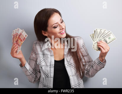 Glücklich Geschäftsfrau Denken dieser Währung zu wählen, Dollar oder Rubel und die Wahl Dollar Geld in verschiedenen Händen hält. Stockfoto