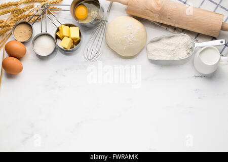 Backen Kuchen, Teig Rezept-Zutaten (Eiern, Mehl, Milch, Butter, Zucker) auf weißen Tisch. Stockfoto