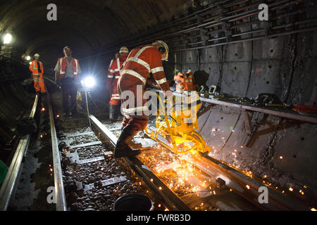 Ingenieure, die Schleifen Ersatz verfolgen Komponenten nach der Verwendung von Thermit Schweißen am Londoner U-Bahn Gleis, London, UK Stockfoto