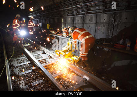 Ingenieure, die Schleifen Ersatz verfolgen Komponenten nach der Verwendung von Thermit Schweißen am Londoner U-Bahn Gleis, London, UK Stockfoto