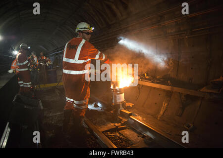 Ingenieure Schweißen Ersatzkomponenten Track zusammen mit Thermit Schweißen am Londoner U-Bahn Gleis, London, UK Stockfoto