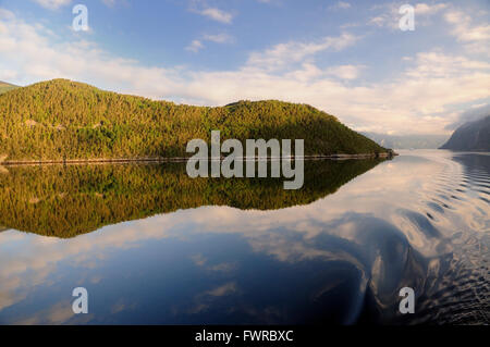 Frühmorgendliche Reflexionen in einem norwegischen Fjord am Mittsommertag. Stockfoto