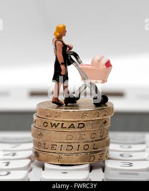 Eine Miniatur Figur Frau mit einem Kinderwagen stehen auf einem Pfund-Münzen Stockfoto