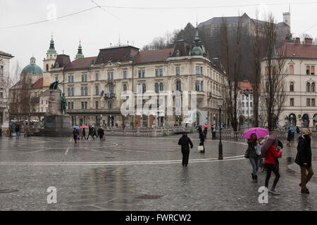 Ein Regentag auf Preseren-Platz in Ljubljana, Slowenien. Die Prager Burg steht auf dem Hügel im Hintergrund. Stockfoto