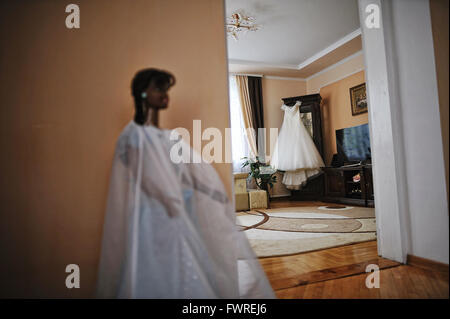 Braut Brautkleid auf Kleiderbügeln am Zimmer Stockfoto
