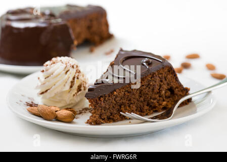 Sacher Torte Stück auf Platte mit frischer Sahne und Mandeln Stockfoto