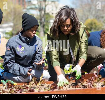 US-Präsidentengattin Michelle Obama neben Student Helfer Pflanzung der White House Küchengarten 5. April 2016 in Washington, DC. In diesem Jahr vorgestellten Garten mehrere Sorten von Gemüse, die auf der internationalen Raumstation angebaut wurden. Stockfoto