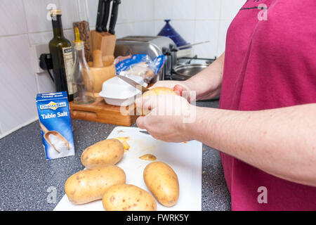 Eine Nahaufnahme von weiblichen Händen Kartoffelschälen in einer Küche Stockfoto