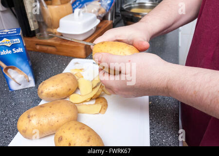 Eine Nahaufnahme von weiblichen Händen Kartoffelschälen in einer Küche Stockfoto