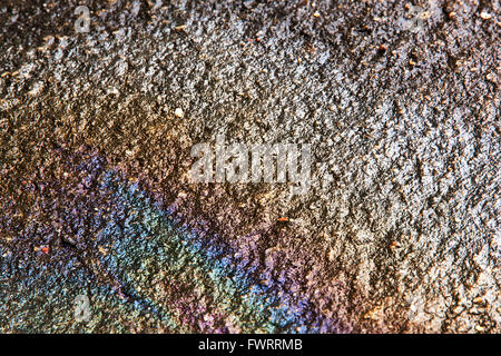 Öl auf nassem Boden Ursache Regenbogen auf dem Wasser am Boden Beton Stockfoto