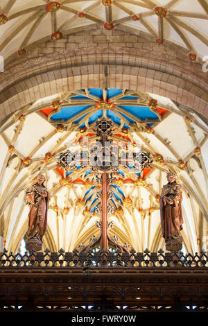 Hölzernes Kreuz vor der dekorierte Gewölbedecke in Tewkesbury Abbey. Tewkesbury, Gloucestershire, England. HDR Stockfoto