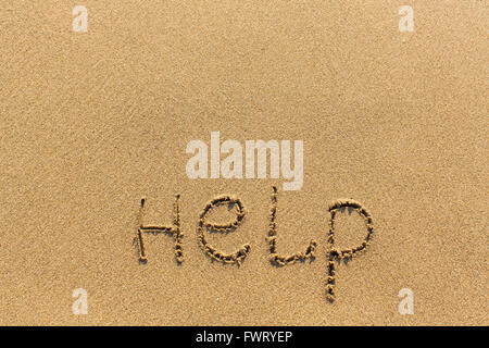 Hilfe - Wort gezeichnet am Sandstrand Stockfoto