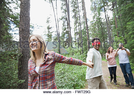 Frau mit verbundenen Augen Mann führt durch den Wald