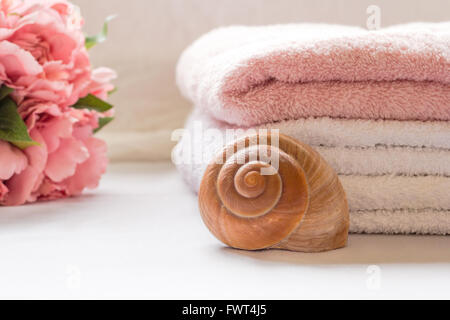 Gefaltete Handtücher auf Waschtisch mit Blumen Stockfoto