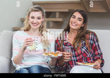 Zwei schöne Frauen auf Sofa sitzen und pizza Stockfoto