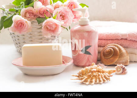 Rosa Rosen, Seife, Handtücher und Muscheln Anordnung Stockfoto