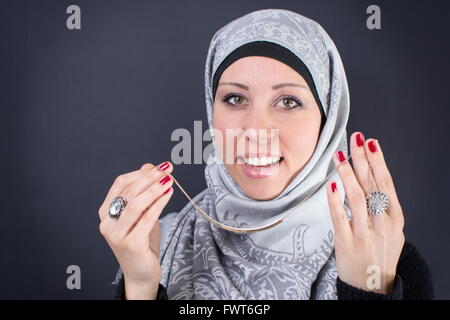 Wunderschöne muslimische Frau, die versucht einer Halskette Stockfoto