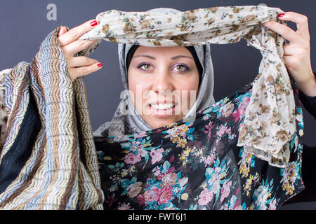 Wunderschöne muslimische Frau, die mit bunten Schals Stockfoto