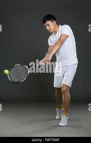 Junger Mann mit dem Tennisspielen Stockfoto
