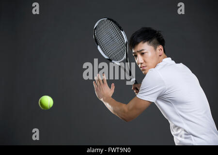 Junger Mann mit dem Tennisspielen Stockfoto