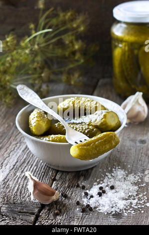 saure Gurken auf einem hölzernen Hintergrund (dunkel) Stockfoto